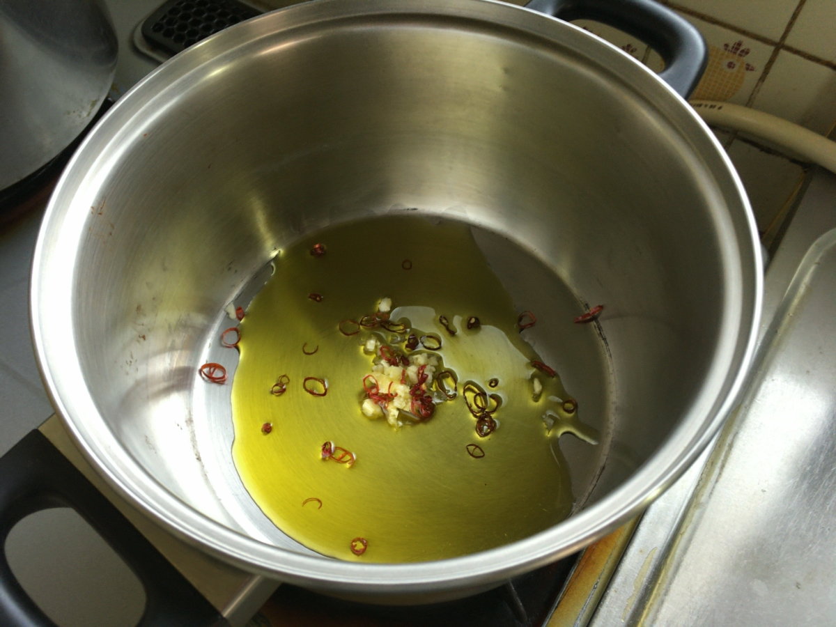 鍋にオリーブオイルをひき、みじん切りにしたにんにくと鷹の爪の輪切りを入れます。鷹の爪はお好みで。